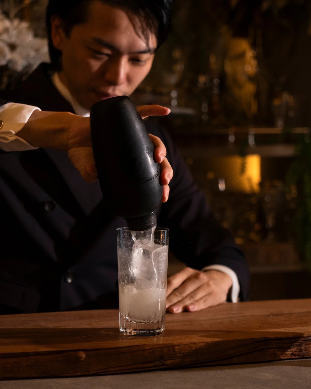 チャコールエディションのシェーカーからカクテルを注ぐ手元